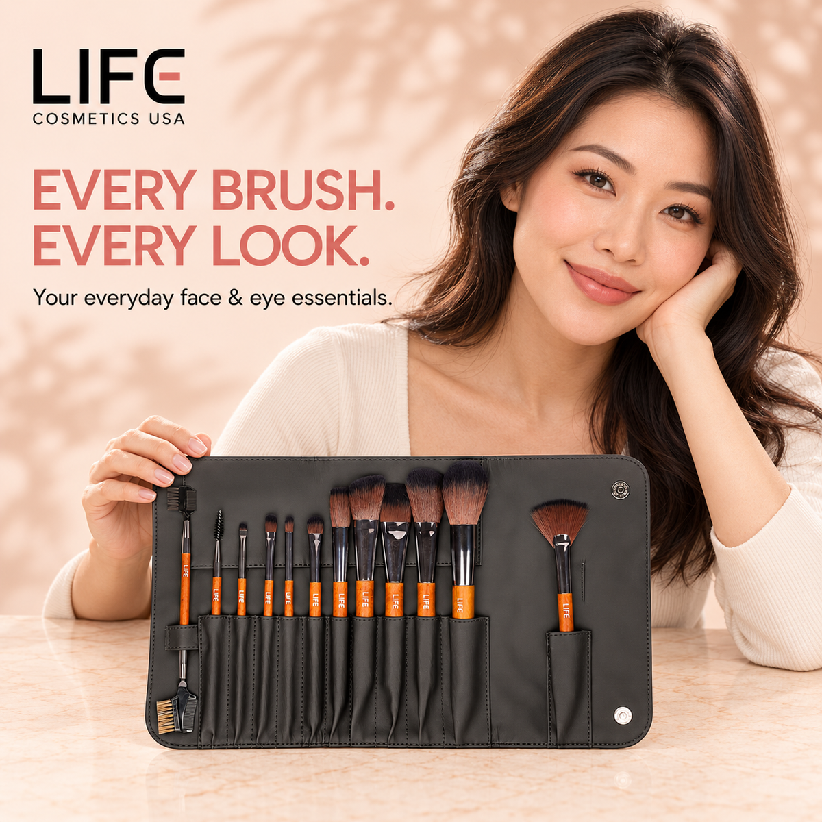 Woman seated at a table behind the LIFE Cosmetics USA 12-piece primary makeup brush set in an open black pouch.