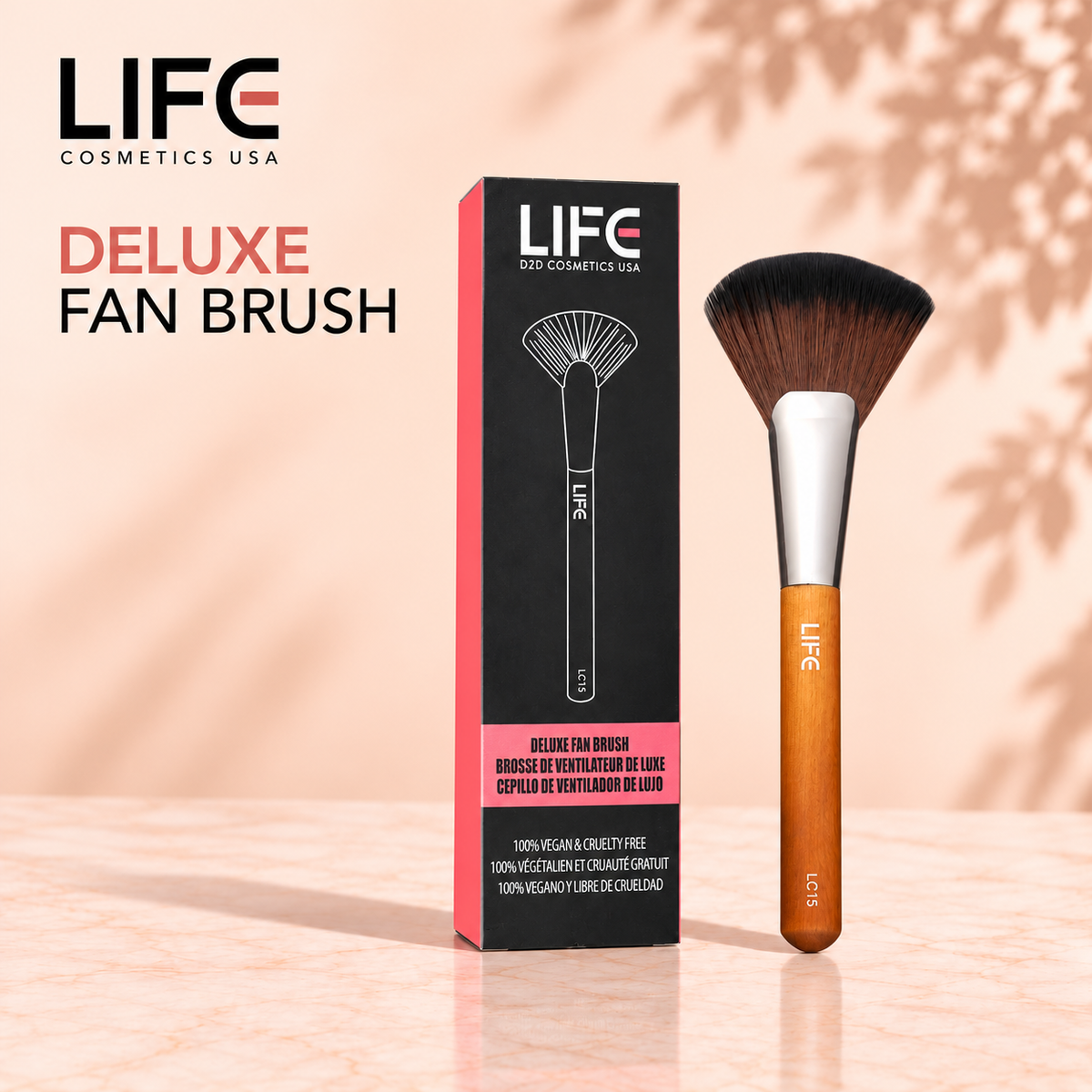 LIFE Cosmetics USA LC15 Deluxe Fan Brush with fan-shaped bristles and a wooden handle beside its black and pink retail box.
