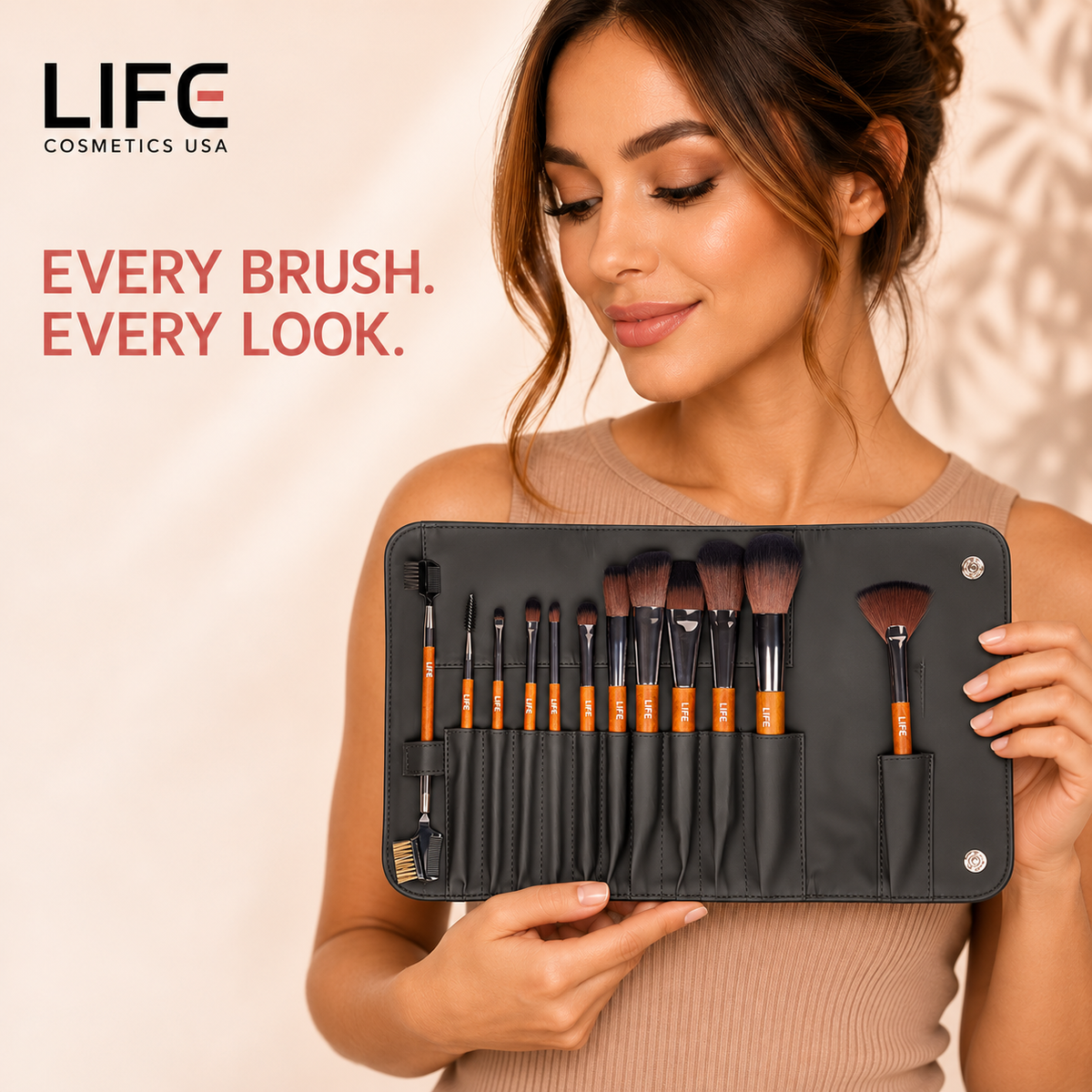 Woman holding the LIFE Cosmetics USA 12-piece primary makeup brush set displayed in an open black pouch.