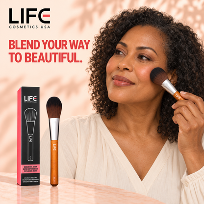 Woman with curly hair applying makeup with the LIFE Cosmetics USA LC11 Medium Oval Brush, beside the brush and retail box.