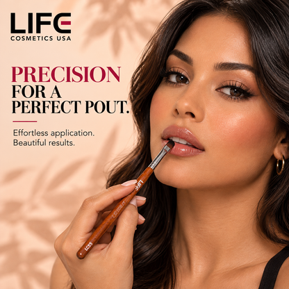 Woman applying lip color with the LIFE Cosmetics USA LC55 Precision Lip Brush, showing its rounded bristles against her lower lip.