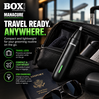 Black MANACURE nose and ear trimmer leaning against an open toiletry bag beside a passport and sunglasses in an airport setting.