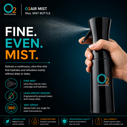 Hand pressing the trigger of a black O2AIR mist bottle, spraying a fine mist to the left against a dark background.