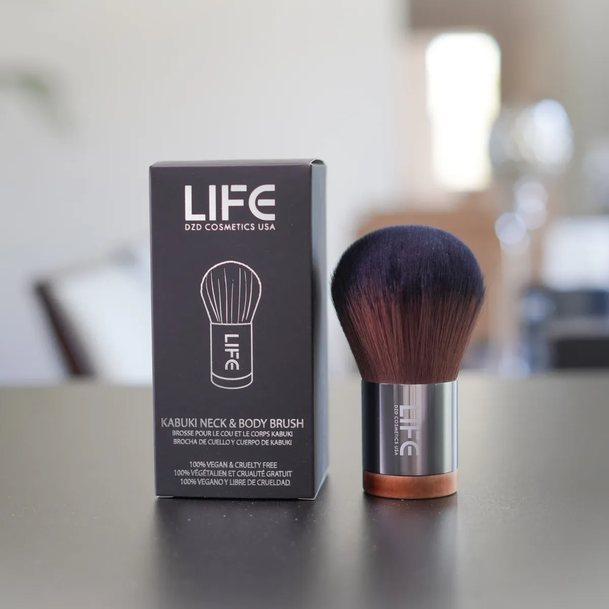 Kabuki neck and body brush with packaging on a blurred background