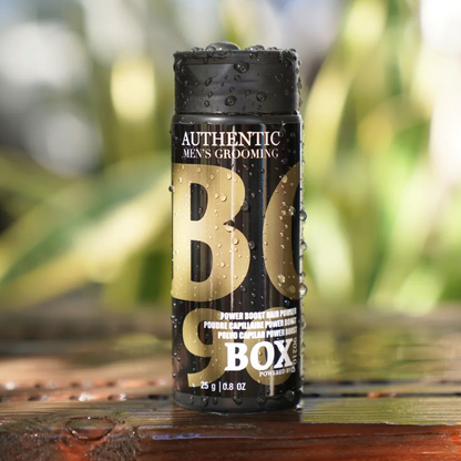 Can of 'BO Box' on a wooden surface with a blurred natural background