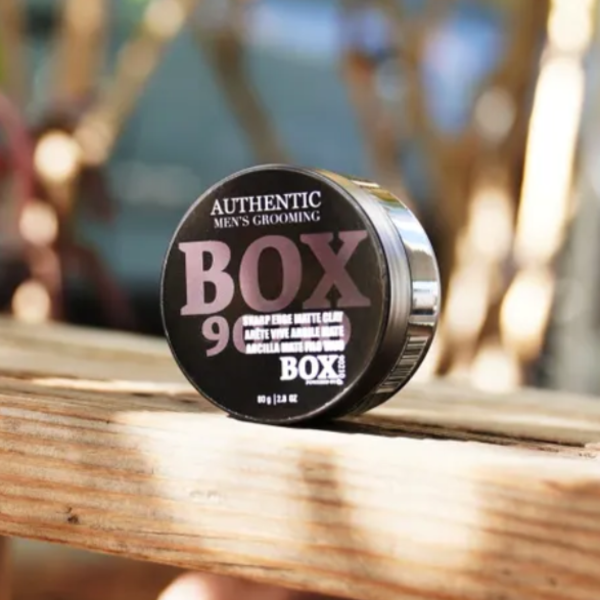 Box of matches on a wooden surface with a blurred outdoor background