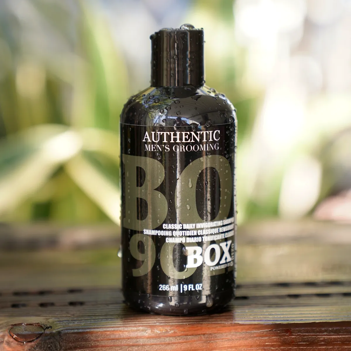 Bottle of 'Authentic Men's Grooming BO 9.0 Box' on a wooden surface with a blurred natural background