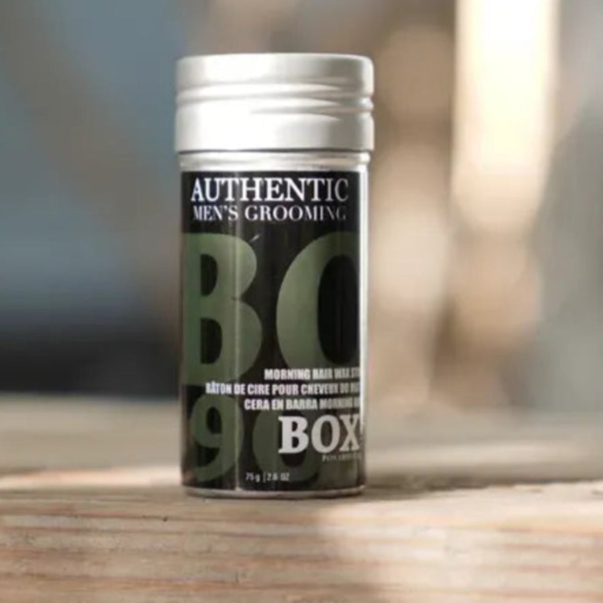 Tin canister labeled 'BC' on a wooden surface with a blurred background